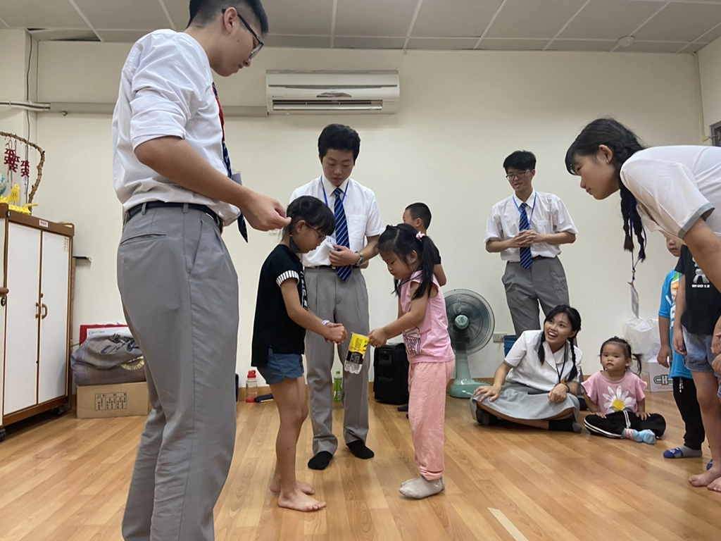 慈大學生帶領孩子2人一組用繩子保持平衡，從a點傳送至b點，訓練孩子的平衡感與團隊合作。