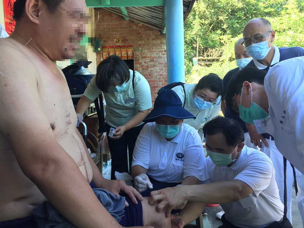 簡瑞騰細心地清理王先生早年車禍在膝蓋留下難癒的傷口，中醫師協助以針灸活絡神經避免肌肉萎縮。