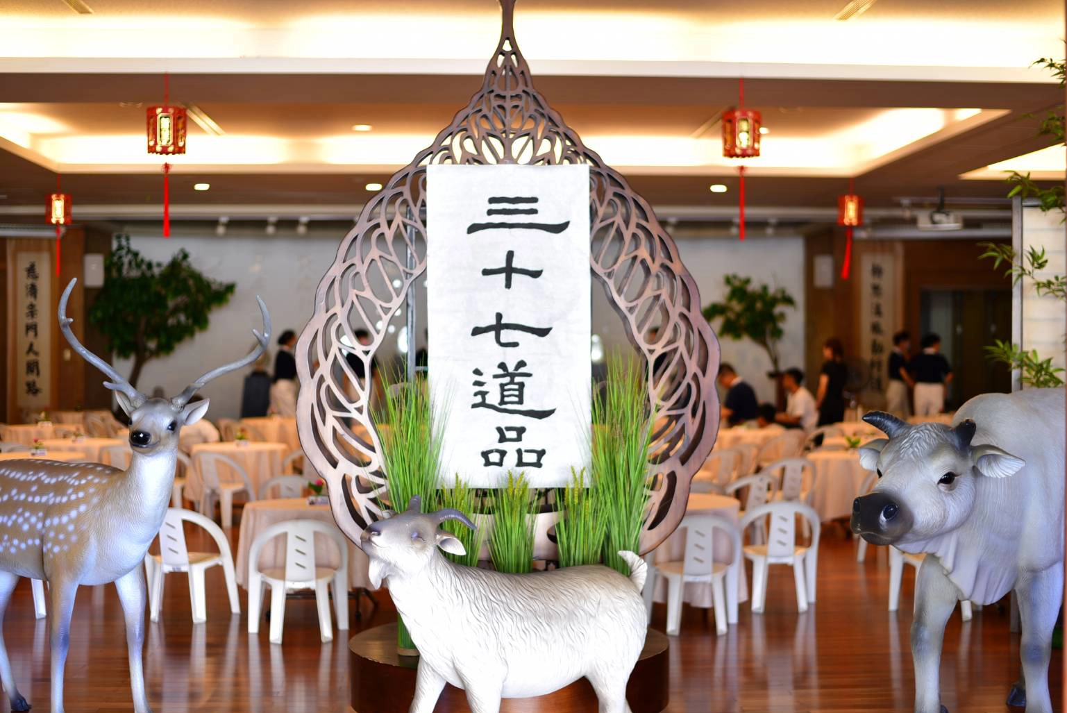 場地佈置是以結合「三十七道品」扣主場，司儀王桂蘭書法寫的「三十七道品」環繞會場，加上大白牛、羊、鹿前導引出道氣莊嚴。
