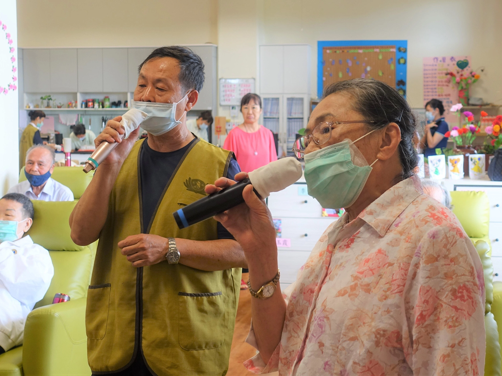 苗栗慈濟日照中心長者楊秋鳳(右)說日照中心每週都會安排一天到戶外走走，今天天氣熱就在室內唱卡拉OK。