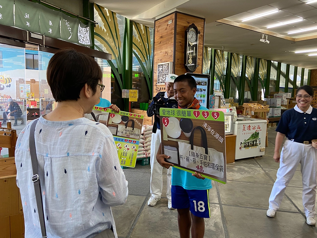 在臺東關山米國學校，豐田國中學子向遊客們進行環保愛地球理念宣導。