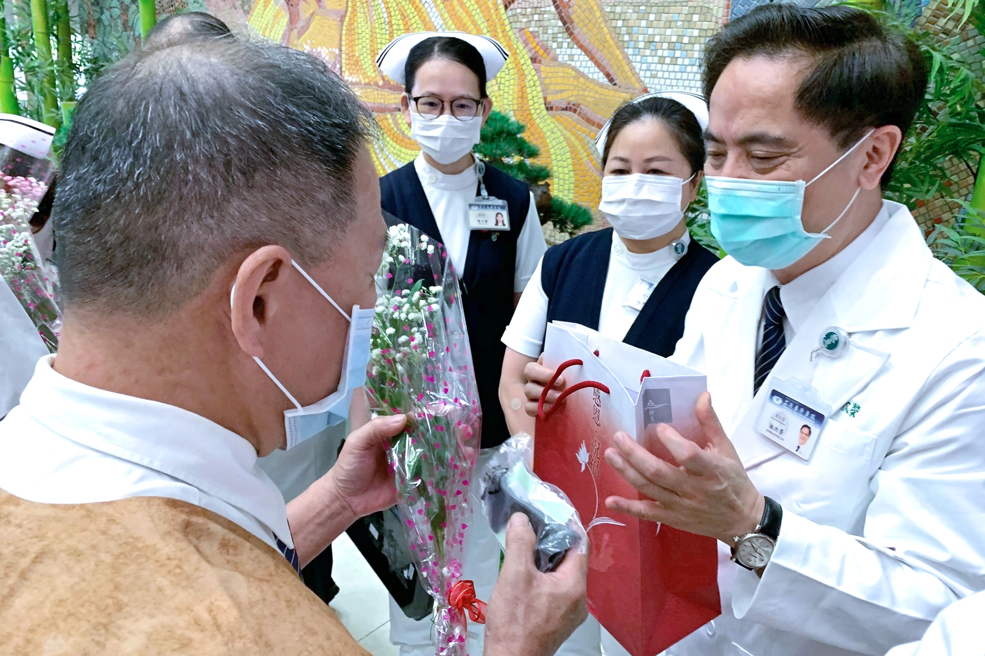花蓮慈濟醫院院長林欣榮帶領團隊，致贈大愛防疫套鏡護目罩組以及充滿愛的玫瑰花，歡迎醫療志工再度「回家」服務。