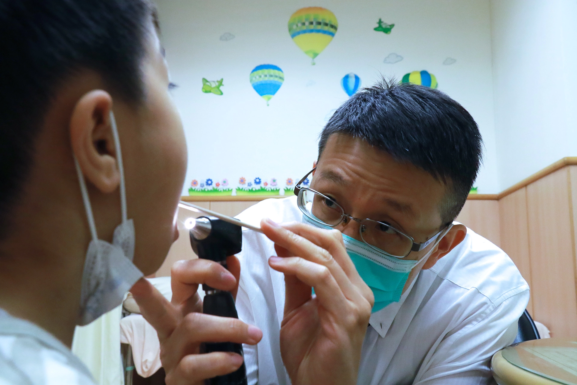 李宜准醫師門診檢查幼童口腔。