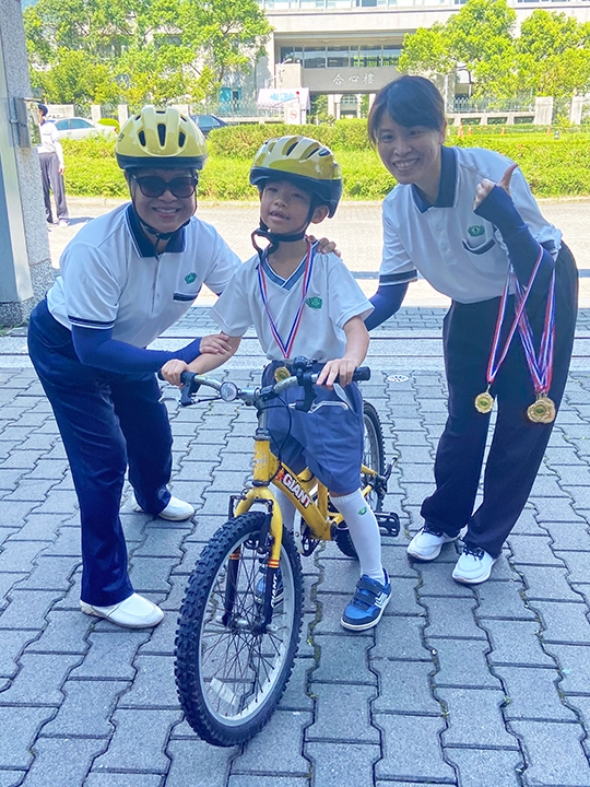 完賽後幼兒從園長陳佩珠手中領取完賽證明獎牌，象徵挑戰成功，順利畢業。
