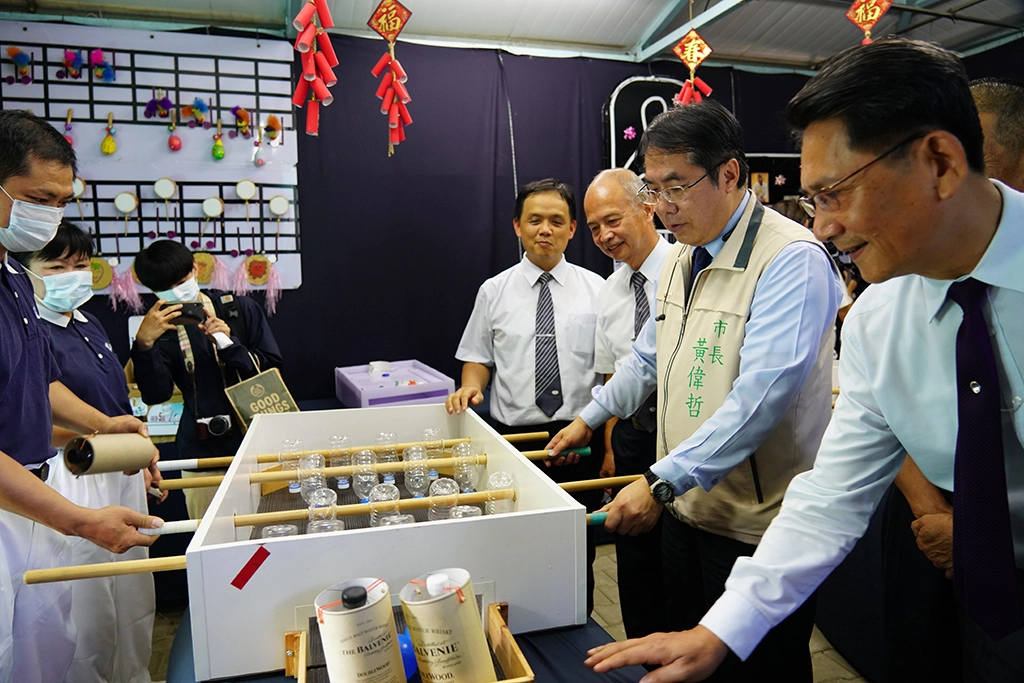 黃偉哲市長參加慈濟綠能館，體驗用回收物製成的遊戲。
