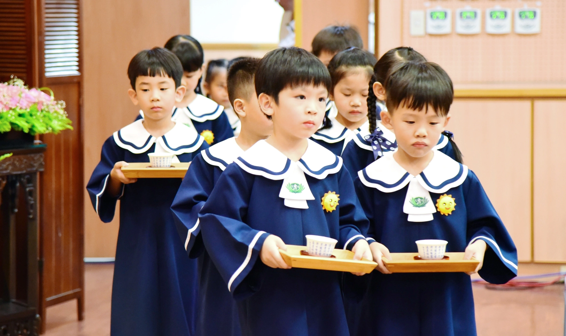2位畢業生小心翼翼地捧著感恩茶，獻給一路無私奉獻、不辭辛勞的家長和師長。