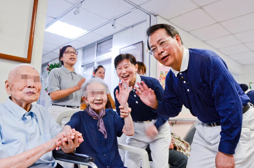 臺北慈濟醫院醫護行政同仁與慈濟志工至北區老人之家關懷長者。圖：副院長張耀仁（右）與長者歡喜互動。