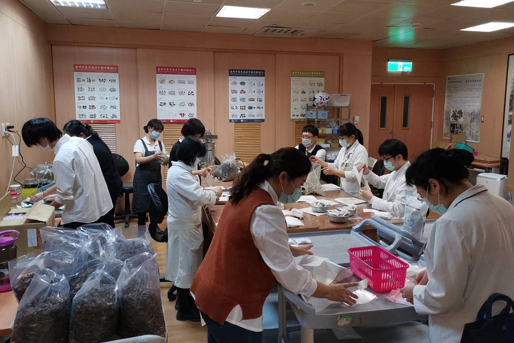 藥學部同仁包裝「養生祈福飲」茶包，表達對師兄師姊的感恩。