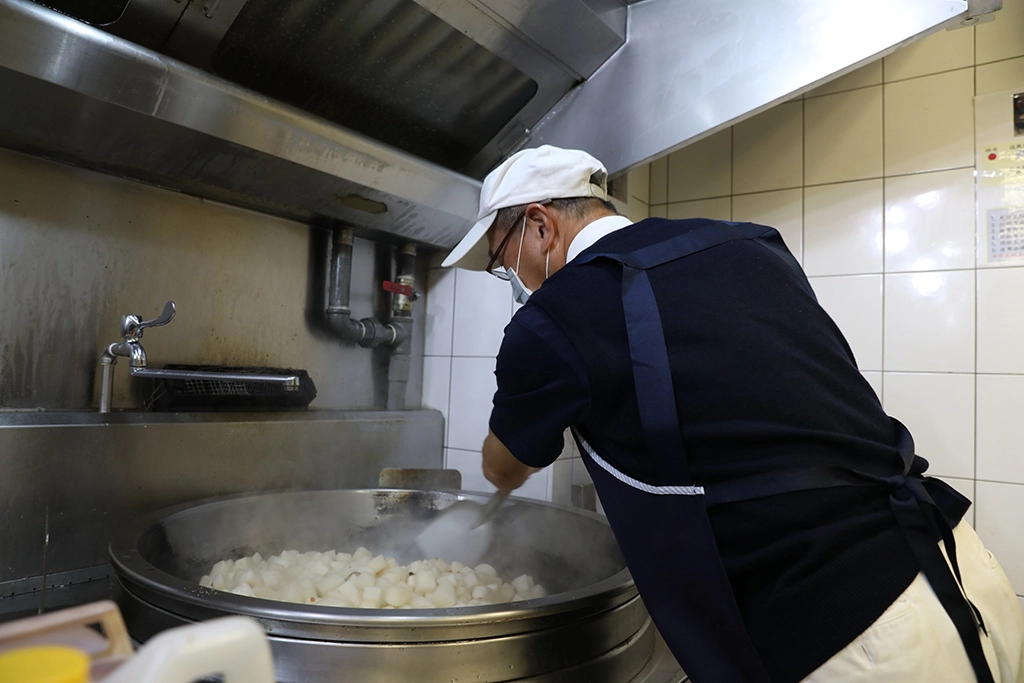 卅位志工就從洗菜、切菜、煮食到打菜、裝便當，如同生產線般井然有序，大家懷著一份感恩及祝福的心，希望透過這份愛心為醫護人員打氣。