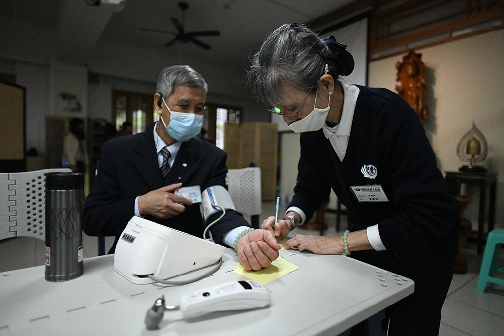 當年和平醫院檢驗技術員張敏如，如今是「專職」慈濟志工，在社區或環保站幫人量血壓，邊聊慈濟，給人紓壓。