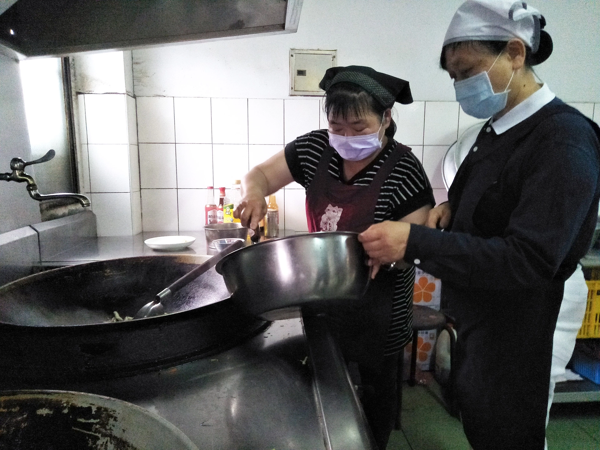 公司負責中餐烹調的曾麗珍小姐(左)，感恩老闆推動素食，他說煮蔬食比較沒有油煙。