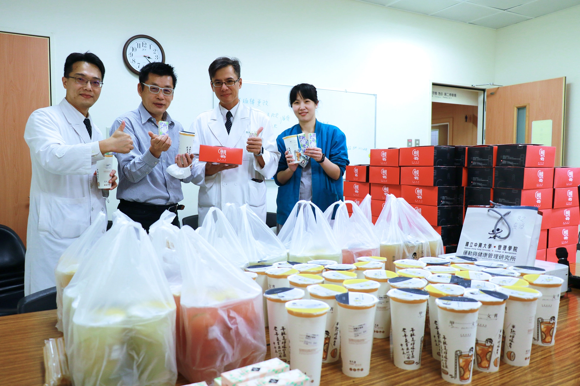 中興大學EMBA學生會長王朝藝（左二)代表致贈茶飲、點心與護手霜等，為一線同仁加油打氣。