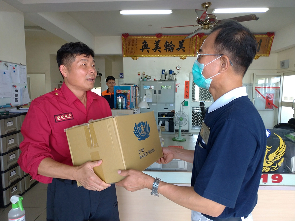 志工賴宏明送便當到消防隊，向保障人民生命安全的小隊長盧豐諒表示慈濟推素用意。