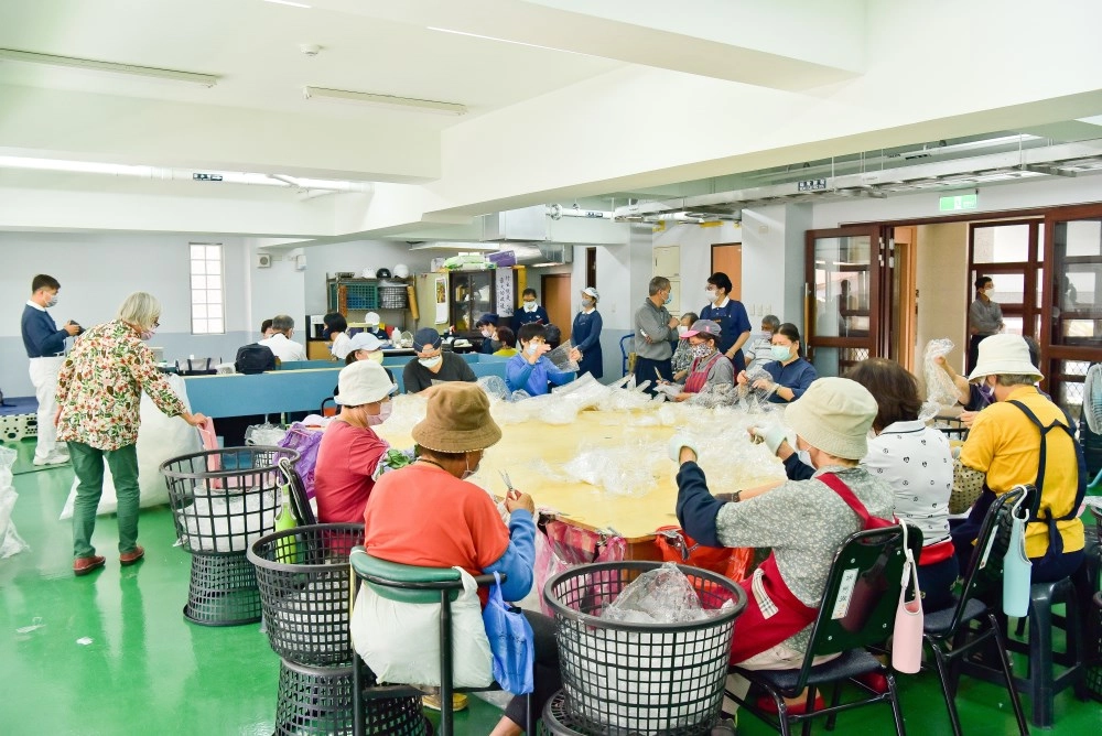志工一邊做分類整理，一邊也輪流到後方由義診團隊調理健康。