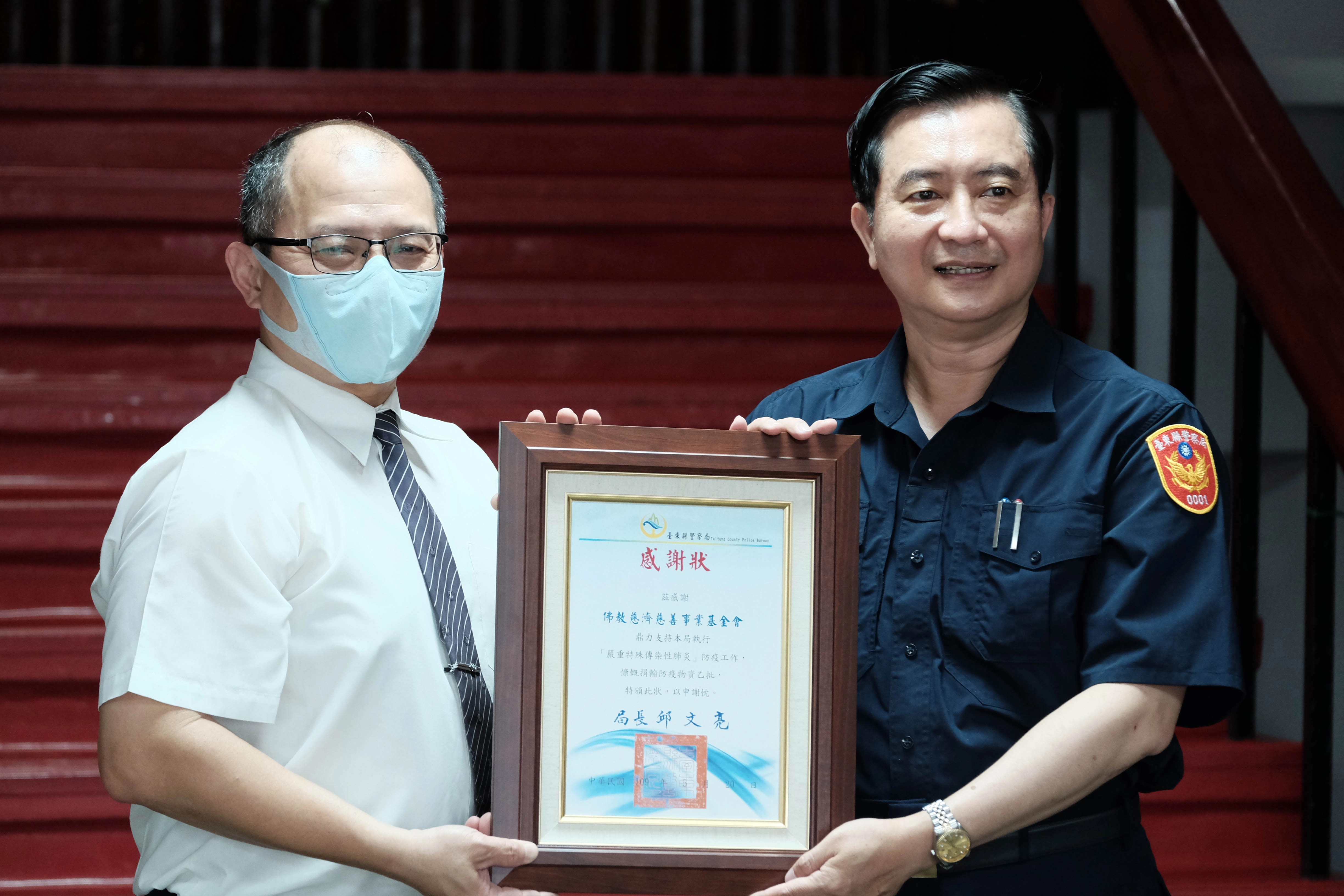 慈濟基金會公傳處組長劉鈞安代表從台東縣警察局長邱文亮手中接下感謝狀。