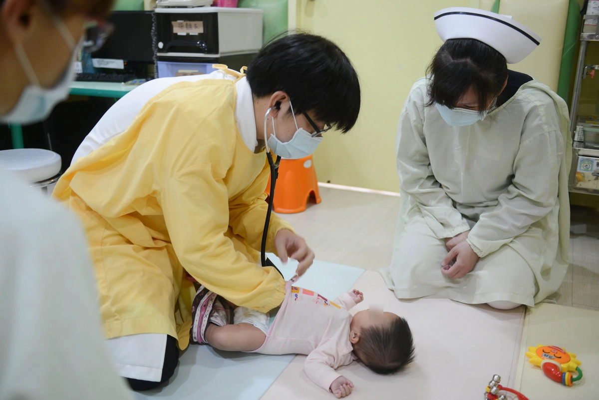 王緒斌醫師為兩歲以下的小小孩評估身體功能。(圖/盧義泓)
