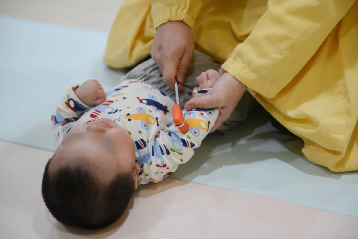 王緒斌醫師為兩歲以下的小小孩評估身體功能。(圖/盧義泓)