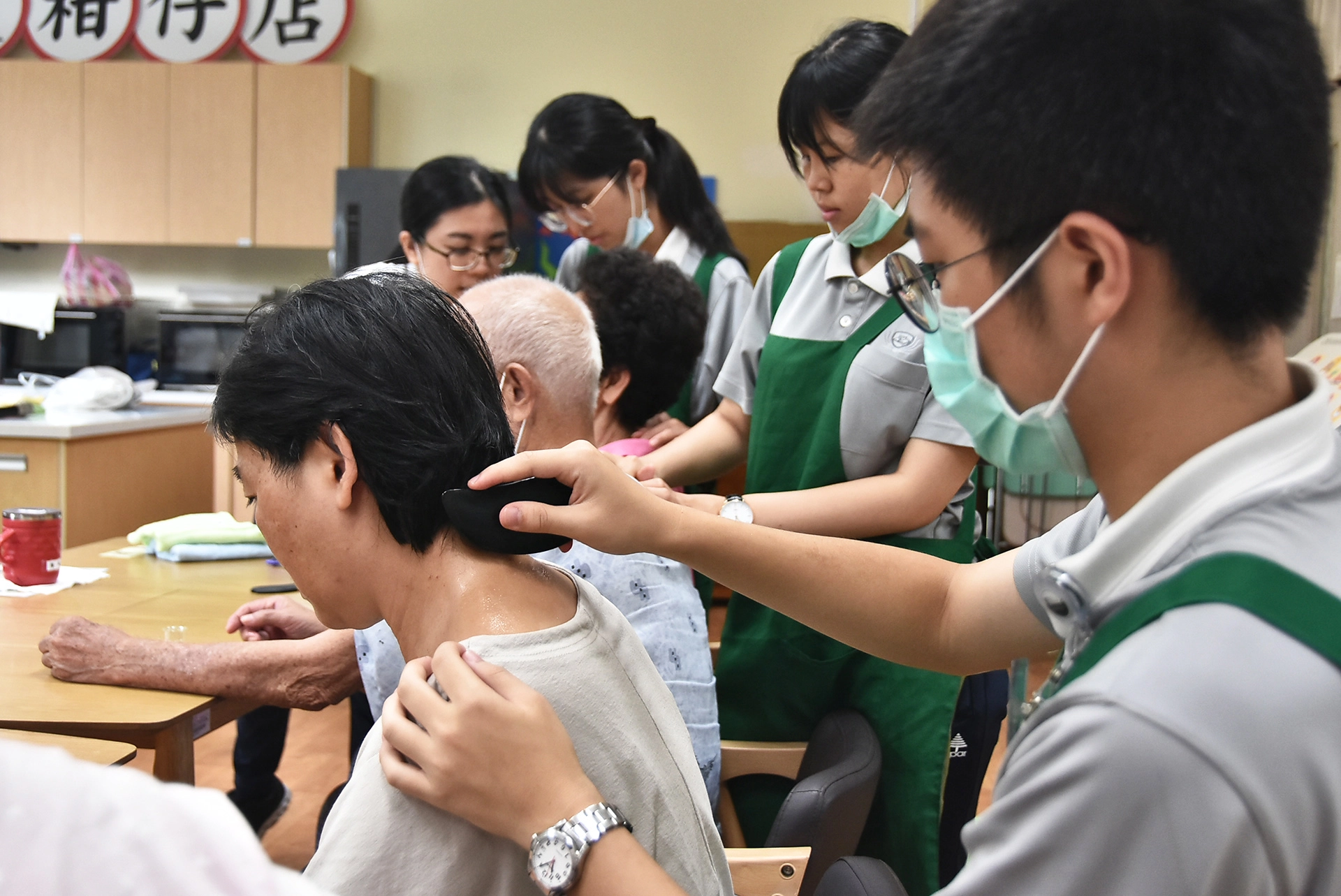 慈科大學生仔細幫阿公阿按摩、刮痧。