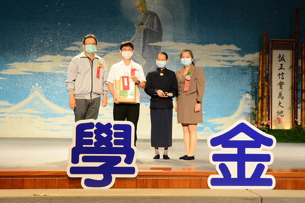 台南高商進修部李正智主任(左)、導師武麗英(右)及陪伴志工出席頒獎典禮，將獎狀頒發給葉俊億(左二)。