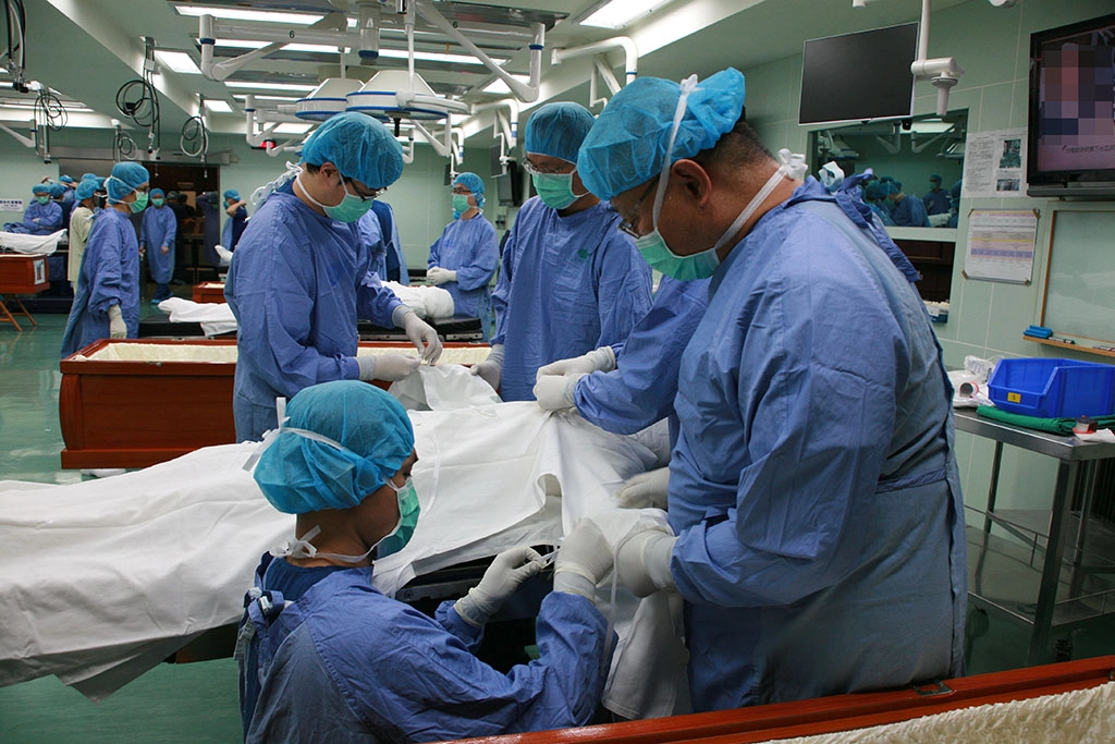  12日課程最後一天晚上，由脊椎外科醫學會32位醫師學員和16位醫師老師，大家帶著至高崇敬的心「將老師的傷口漂亮的縫合」，並為八位無語良師著衣、入殮。