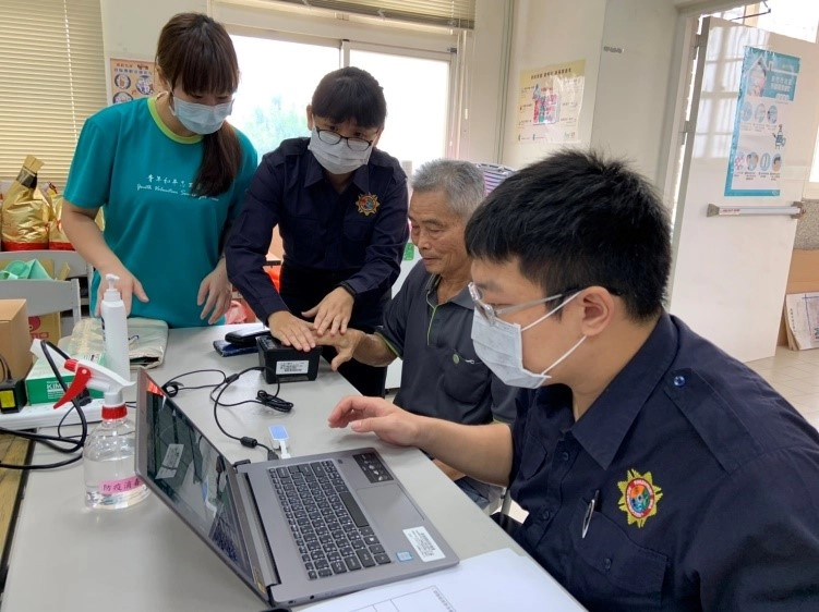 青年志工協助長輩捺印指紋