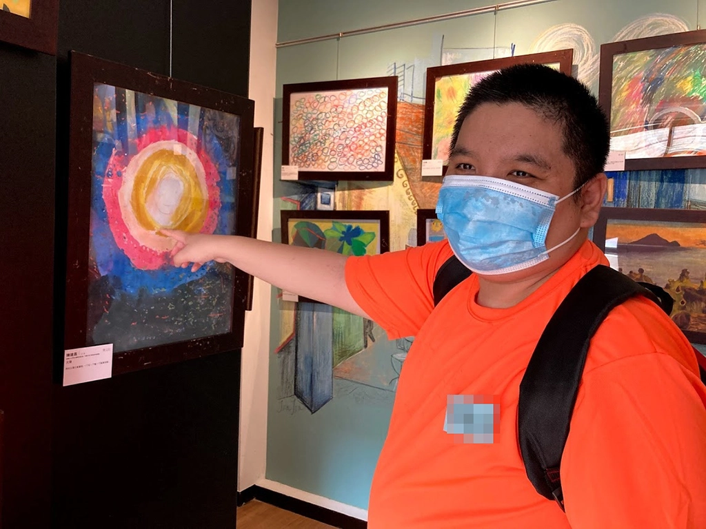 阿昌很開心看到自己的畫作被展出。