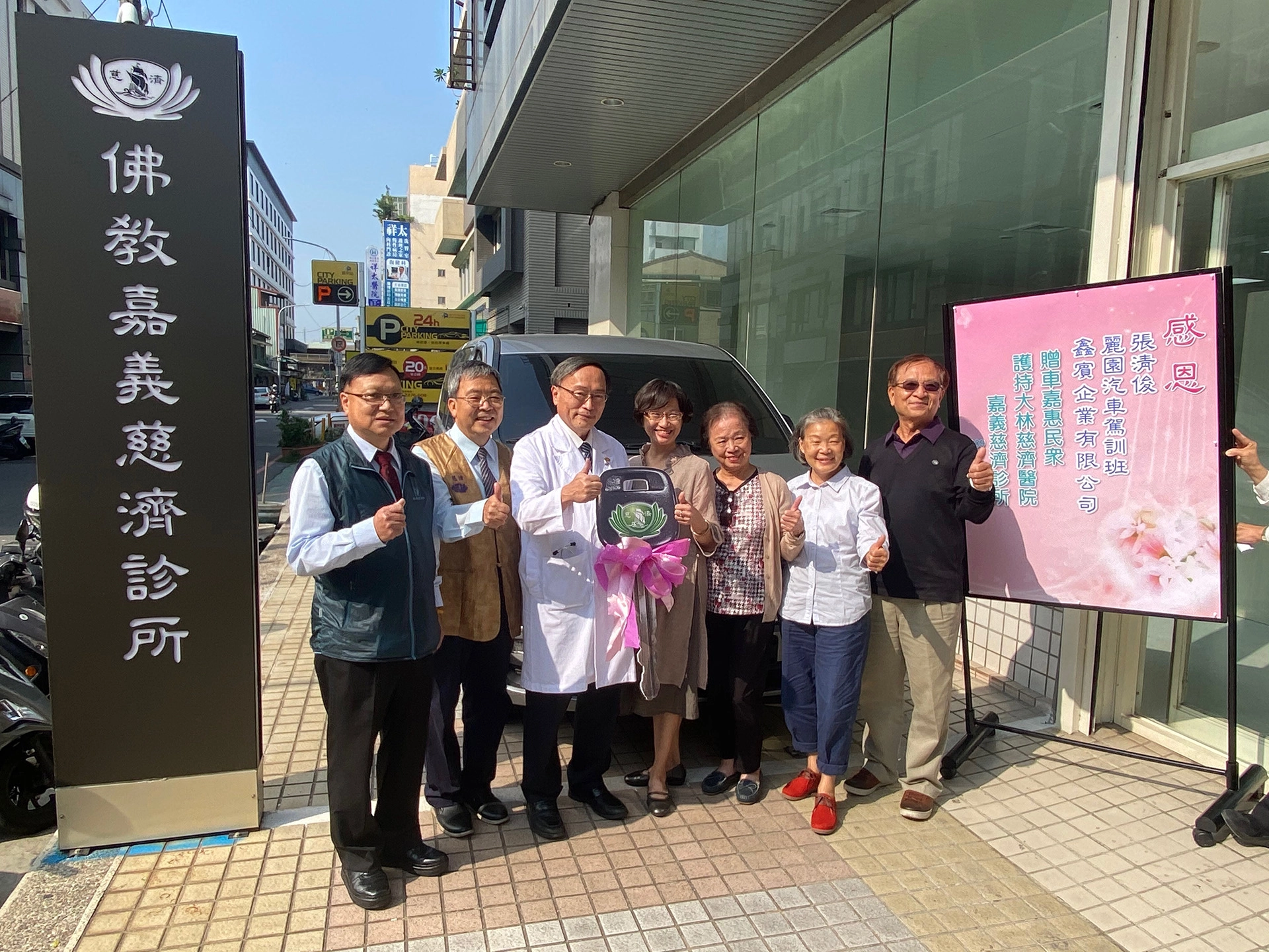 與捐贈公務車在嘉義慈濟診所外合影