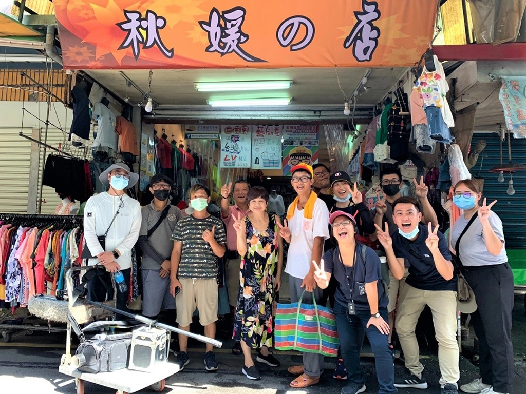 青年開心於宜蘭菜市場中經營超過40年、同時也是團隊成員方子維的家「秋媛的店」合影，透過市場導覽的過程中，認識宜蘭在地故事。