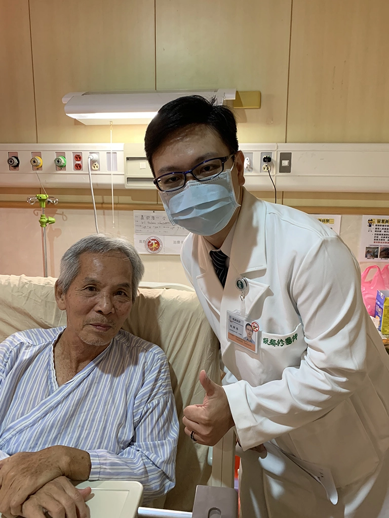 術後蕭先生在手術台上就聽從指令高舉雙手，2天後就能下床自行如廁，回復狀況良好，開心地與神經介入診療科阮郁修主任合影。