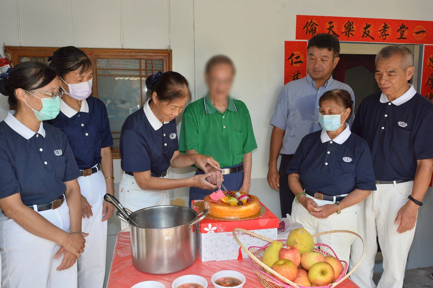 志工陳惠卿代表與劉先生一起切蛋糕，慶祝新居圓滿。