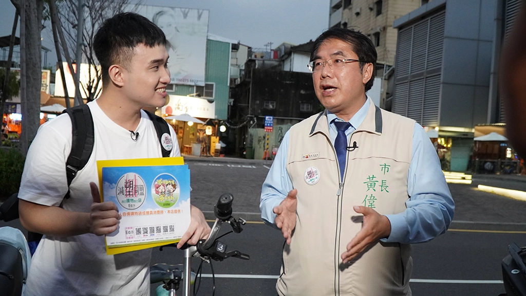 大愛電視台「一口家族」節目主持人陳煌升(左)與臺南市長黃偉哲，一起在海安商圈宣導「臺南減廢日暨減塑同盟雙認證活動」。