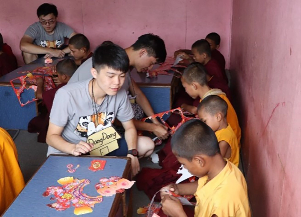 國防醫學院享尼尼泊爾國際志工團團員在佛學院進行元宵節慶課程，教導孩童製作燈籠。