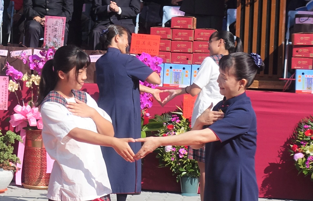 公館國中學生與慈濟志工帶來手語表演〈陽光眷戀的地方〉：「多少汗水砌成一道牆，多少苦心聚成一個家…」。