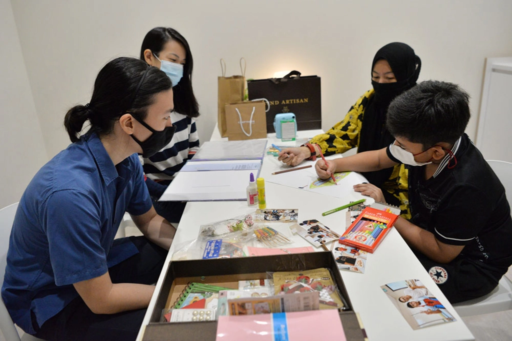 慈青課輔老師和學生一起製作相冊，寫上祝福語、貼上合照，在彼此心中留下美好的回憶。