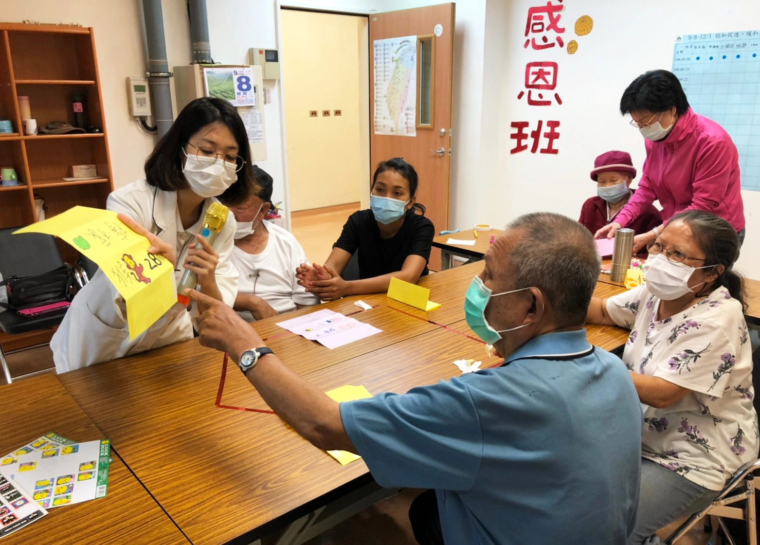 職能治療師林易萱指導學員製作名牌，運用玩接龍遊戲，讓家屬及長輩做記憶認知保養。