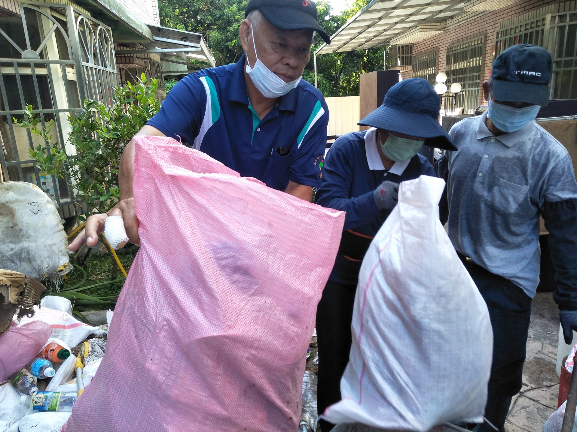 御史里洪智捷里長(左)雖然手指有傷仍跟夫人一起投入清理行列。