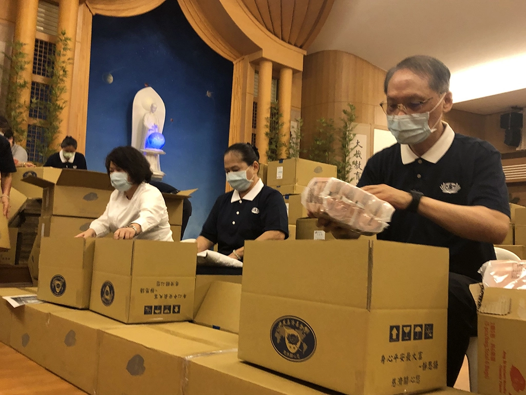 嘉義市長黃敏惠(左)、慈濟慈善事業基金會執行長顏博文(右)參與包裝安心生活箱。