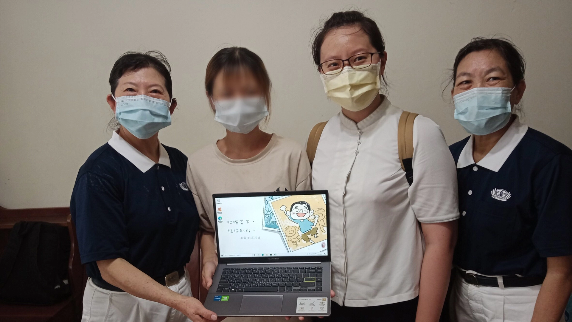 學子拿到全新筆電，高興與志工合影。