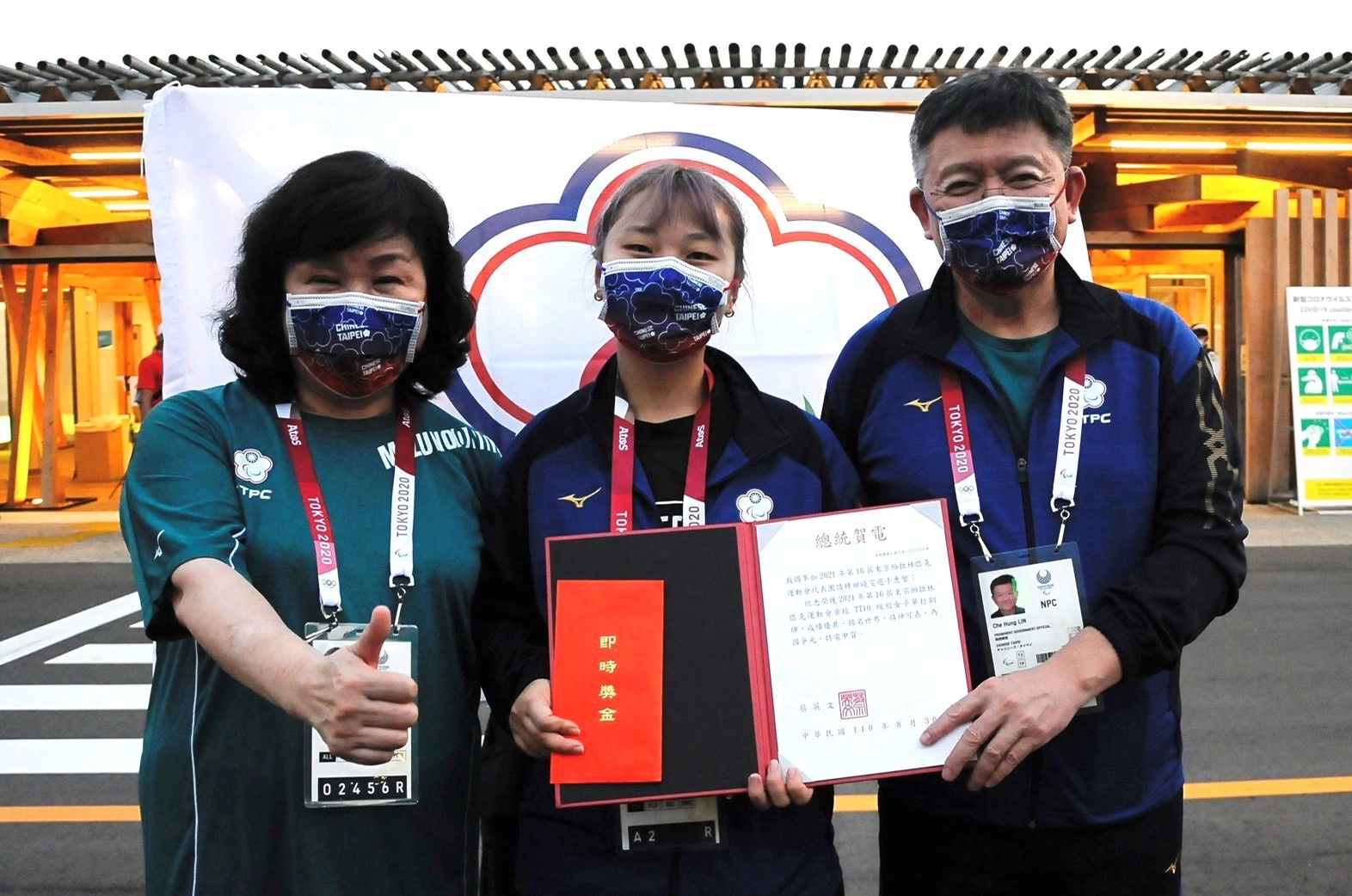 教育部體育署林哲宏副署長(右一)親自到選手村頒發總統賀電。