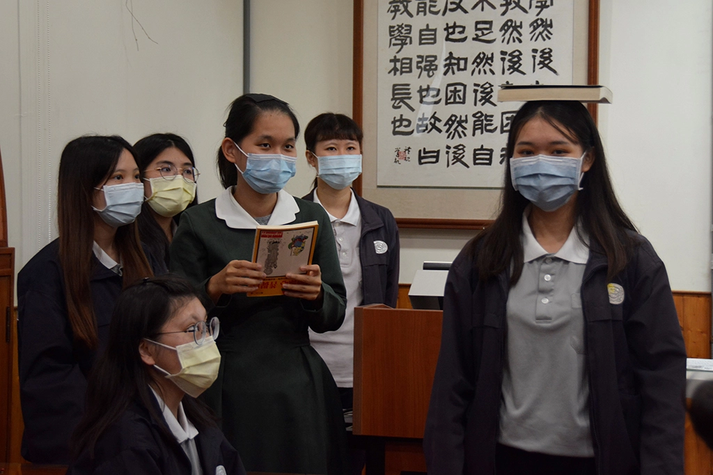 學生頭頂書本，練習直線走路，才知道抬頭挺胸，姿勢端正有多重要。