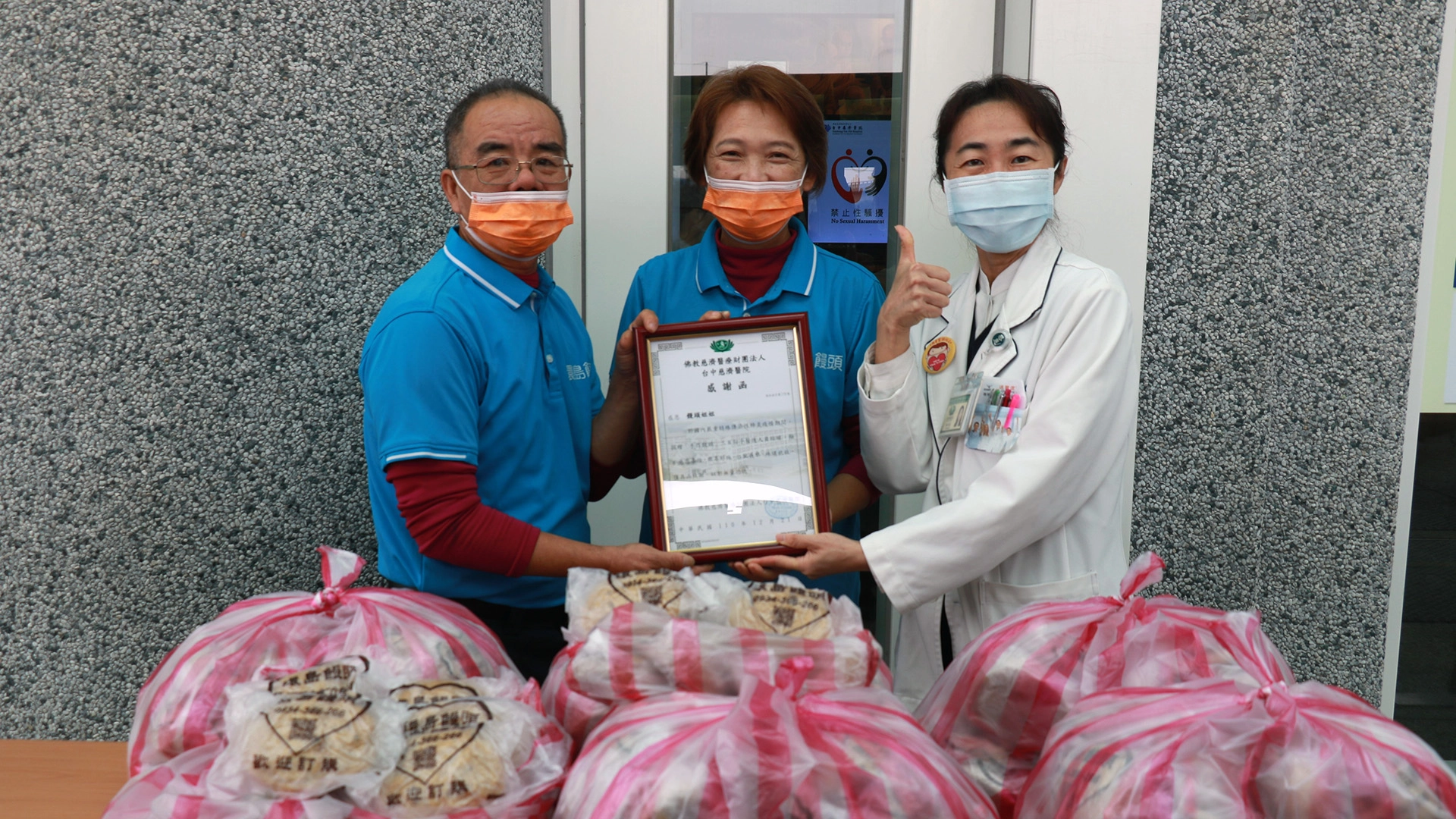 臺中慈濟醫院社會服務室主任林怡嘉（ 右）致贈感謝狀，感恩「環島饅頭」夫妻的善行與毅力。