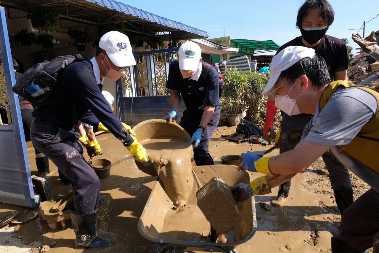 馬來西亞遭逢水患，慈濟志工號召民眾一起投入清掃工作。(圖為慈濟基金會提供)