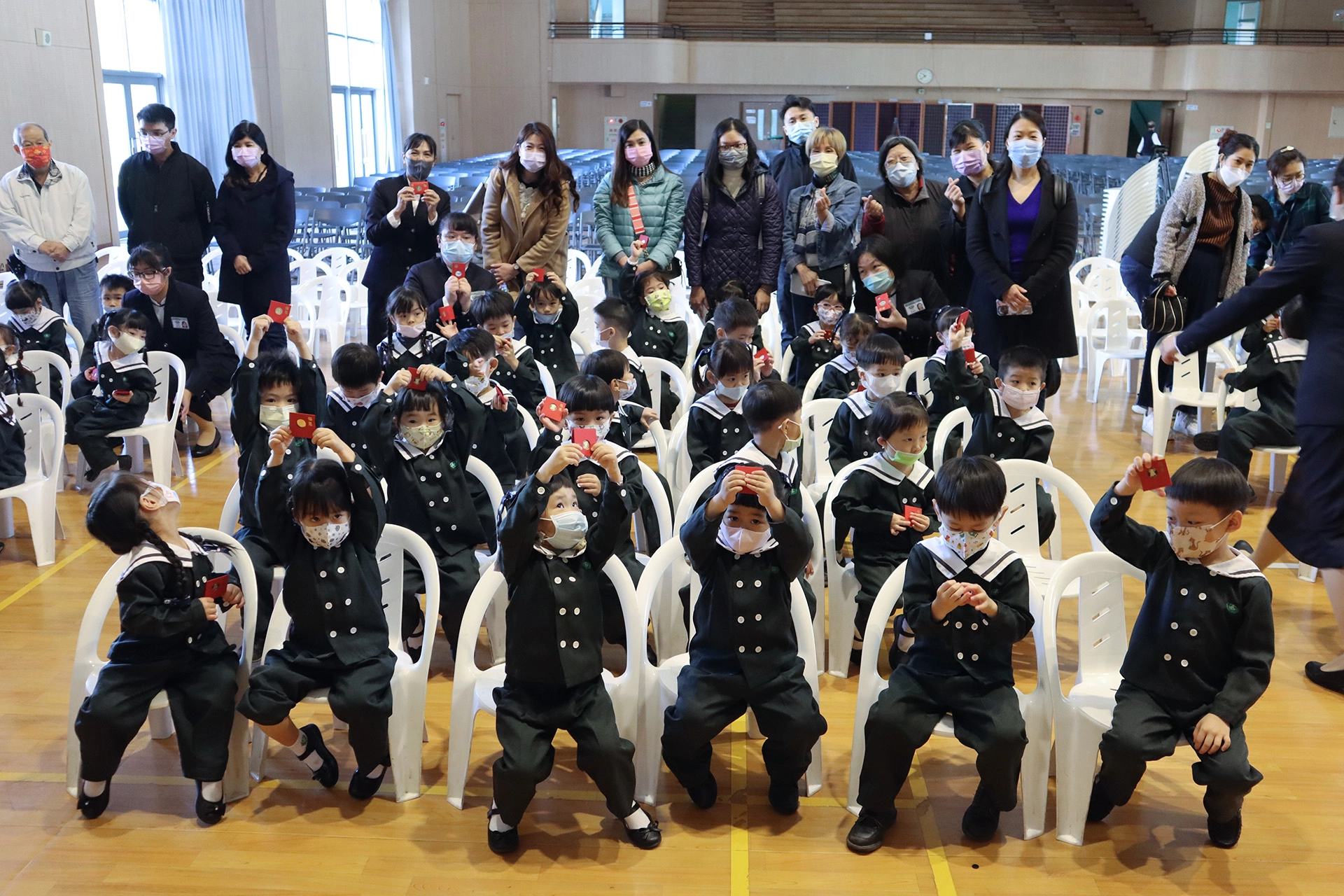 第一次和爸爸媽媽一起在學校參與歲末祝福，幼兒園的孩子開心地展示手中的福慧紅包。