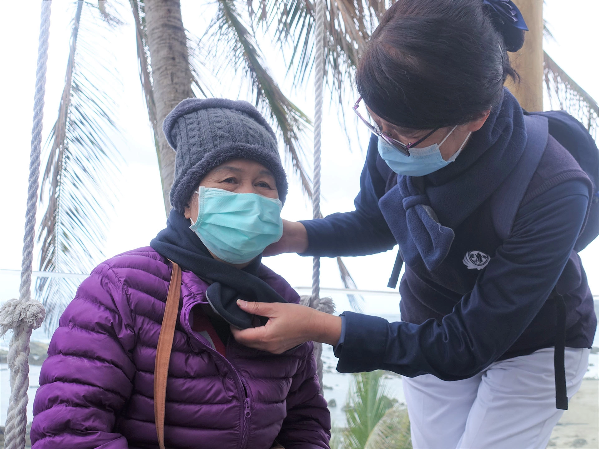 1月30日台東慈濟社工與志工帶王阿嬤到海邊看海，志工擔心海風大，為阿嬤圍上圍巾。
