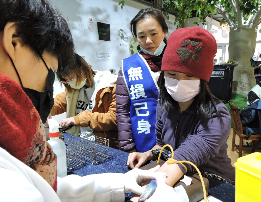 志工許育珮穿上「捐髓救人、無損己身」的背心，親切陪伴前來響應的民眾。