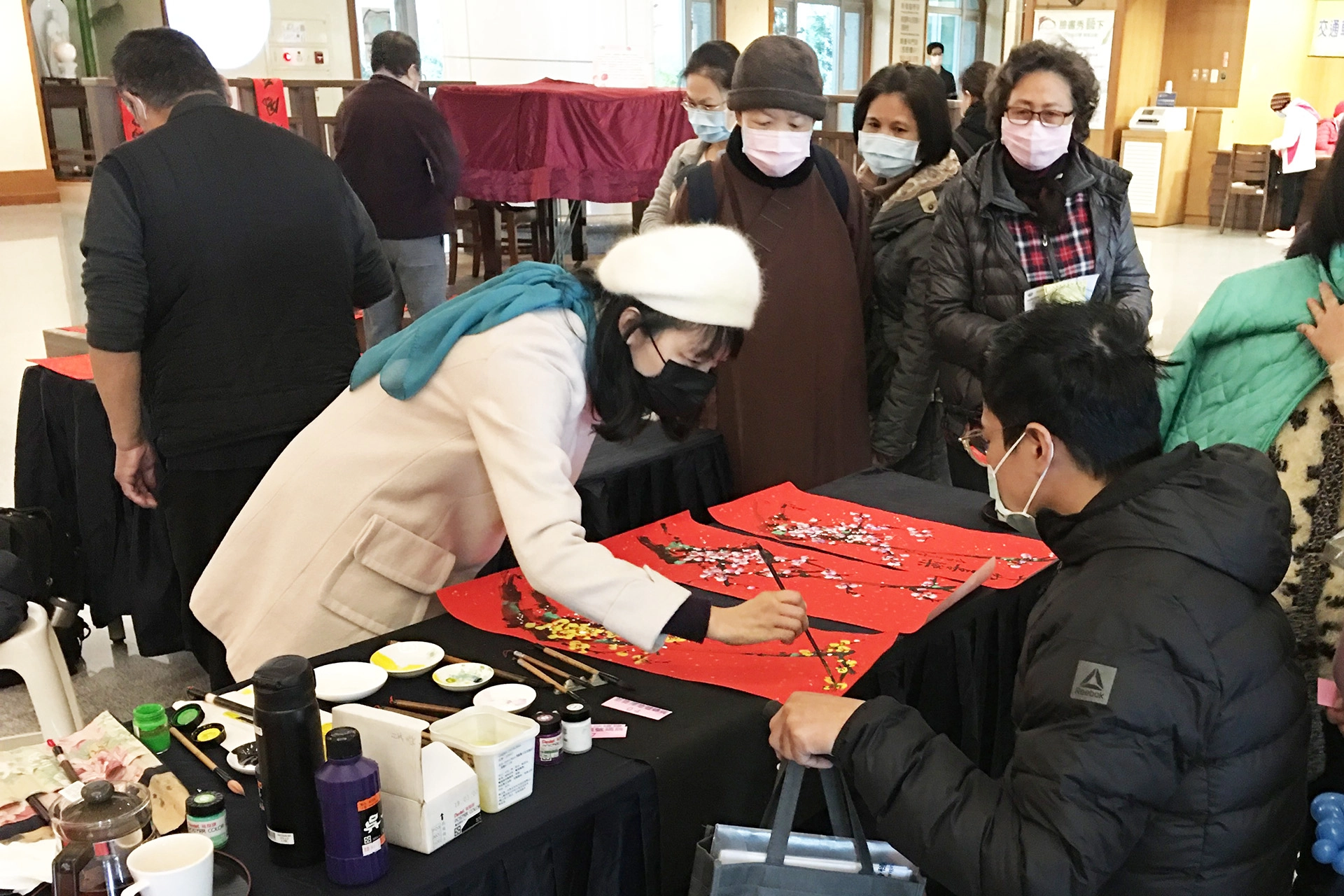 李堃菁老師（左一）表示，年畫呼應最近寒流的高山降雪，畫中點點雪花象徵著「瑞雪兆豐年」，用吉祥年畫祝福大家牛年順順利利、平安快樂。
