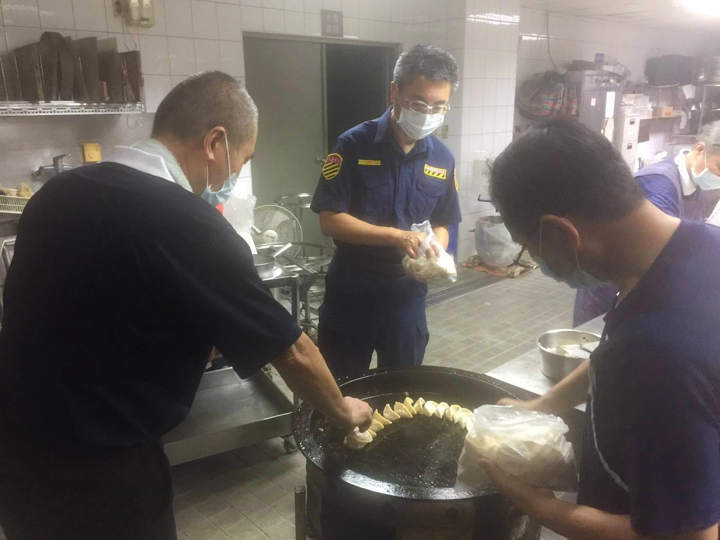 臺南市警局學甲分局長翁誌宏(中)與慈警會推動素食，他與同仁幫忙煎鍋貼。