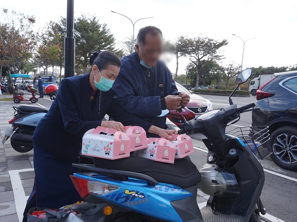 慈濟志工協助照顧戶將發放物資品搬上車。