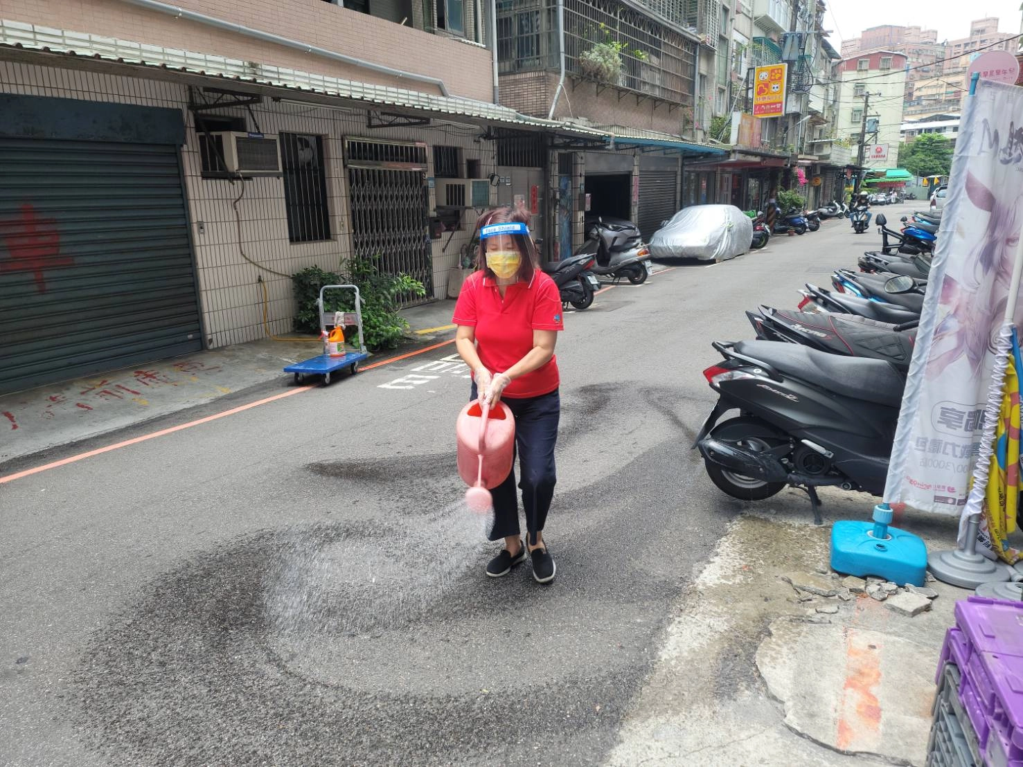 永和區民權社區照顧關懷據點防疫志工幫忙社區里鄰做消毒。