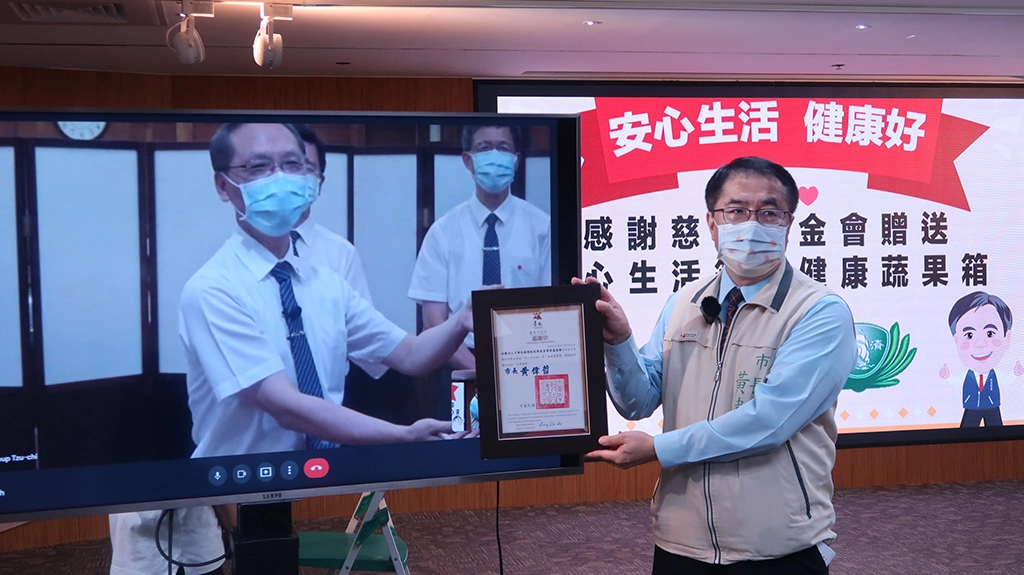 慈濟捐贈台南市政府5880戶弱勢學生家庭暑期「安心生活箱」及「健康蔬果箱」，黃偉哲市長(右)代表致贈感謝狀。(攝影：台南市政府)